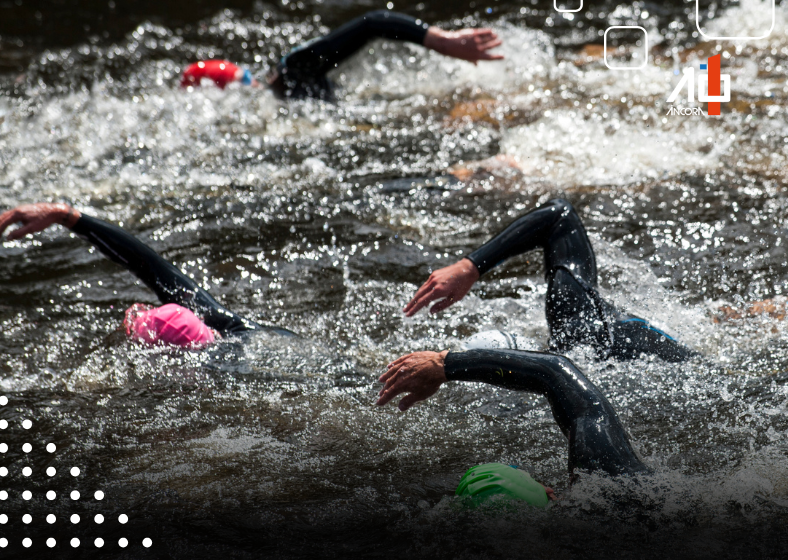 Triatletas nadando em águas abertas durante competição